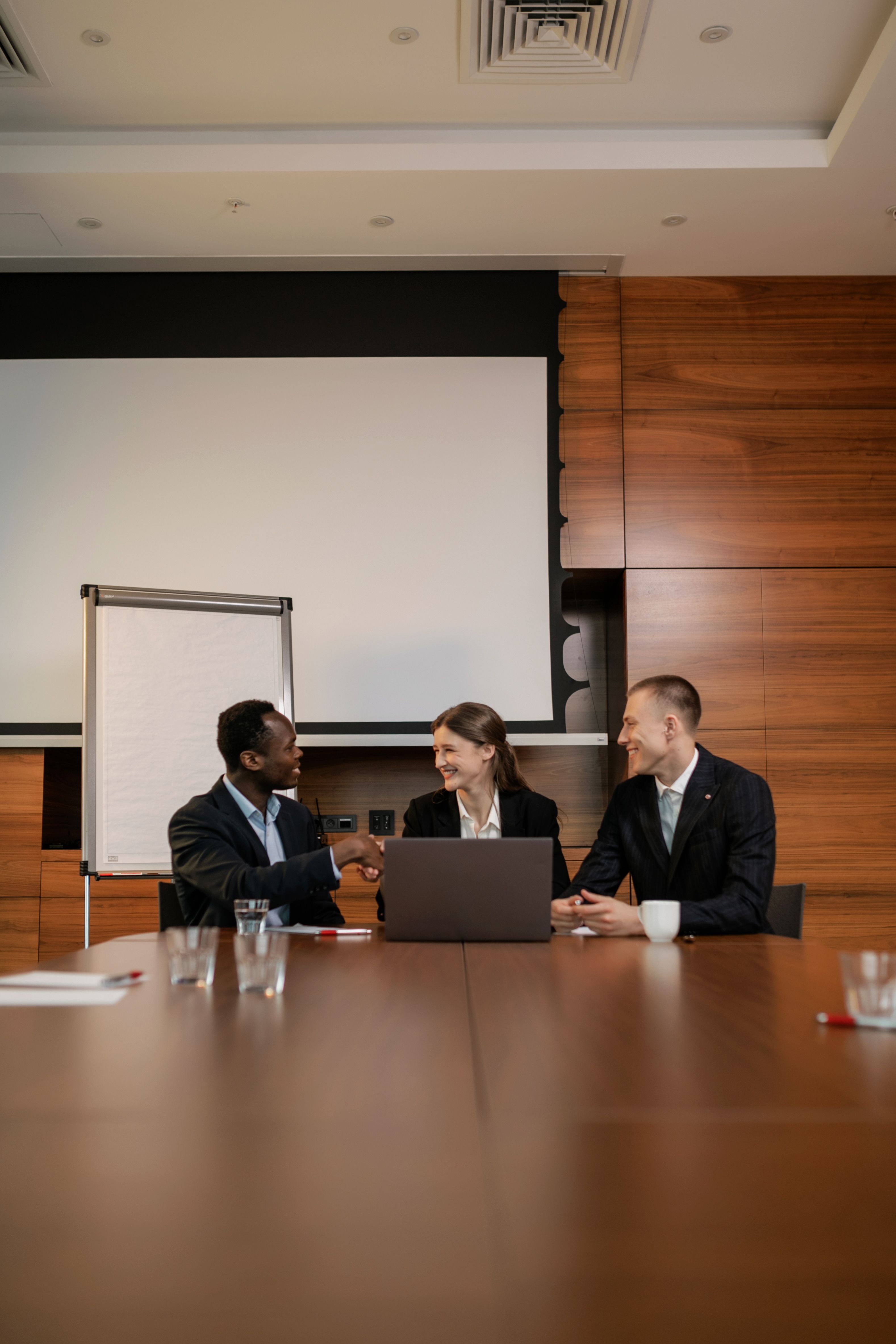 Business professionals shaking hands during a meeting in a modern boardroom